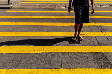 Tourist man in shorts and sandals crossing road in Hong Kong