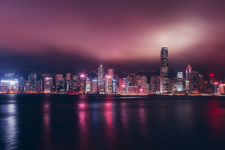 Hong Kong skyline on Victoria Harbour with moody mist and clouds