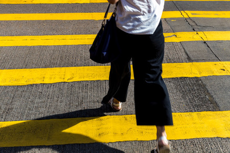 Walking woman crossing road at Causeway Bay shopping district Ho