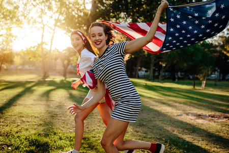 Female friend running with American flag