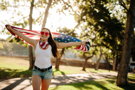American woman celebrating independence day at park