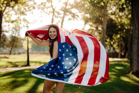 Patriotic girl with american flag in the park