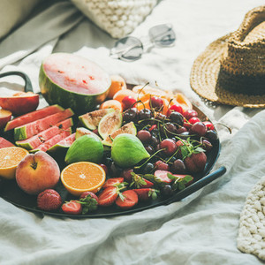 Tray full of fruit over light blanket background  square crop