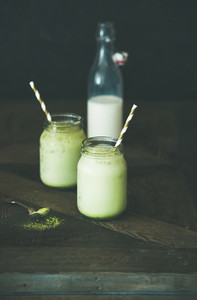 Refreshing iced coconut matcha latte drink in jars  copy space