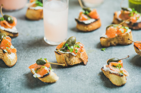 Crostini with smoked salmon and pink grapefruit cocktails  grey background