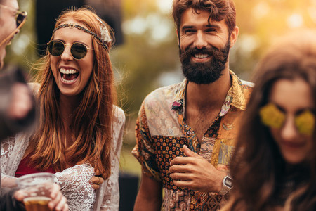 Happy young hippie friends at music festival