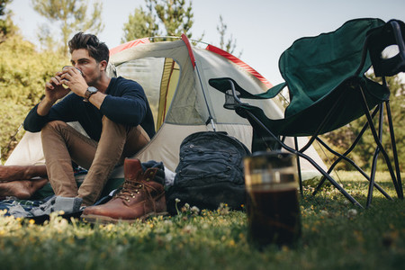 Man in tent drinking coffee