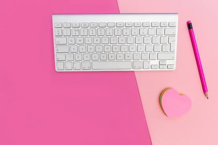 Computer keyboard on pink background minimal workspace concept