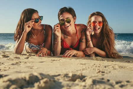 Woman friends sunbathing and enjoying at the beach