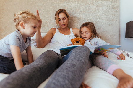 Mother reading bedtime story to children