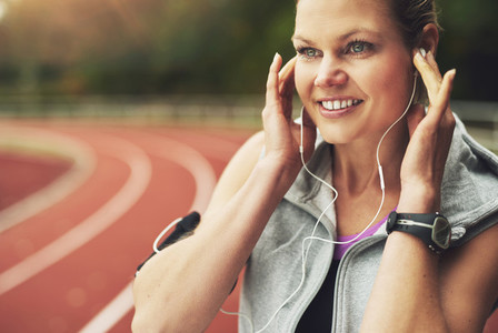 Close up of smiling female athlete listening to music