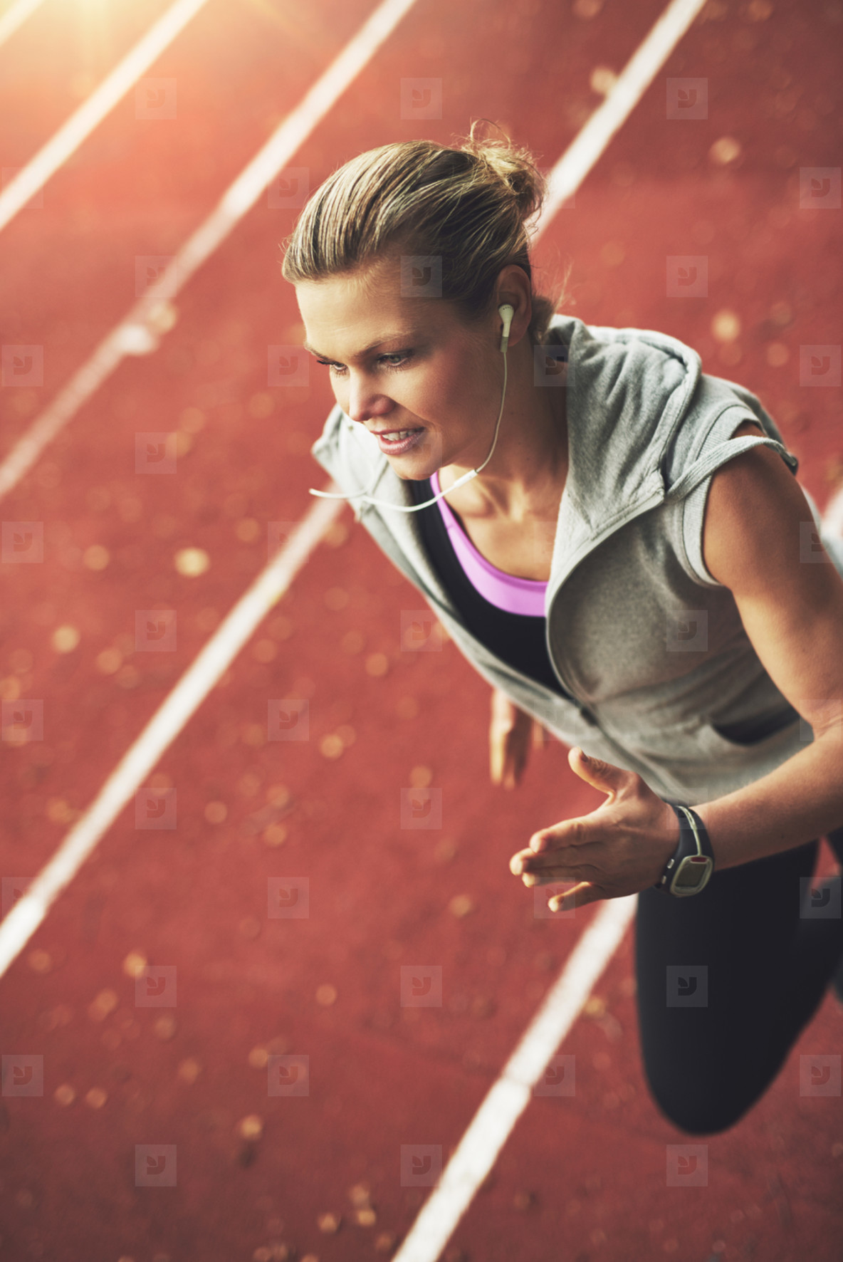 Close up of athletic young woman running fast on stadium