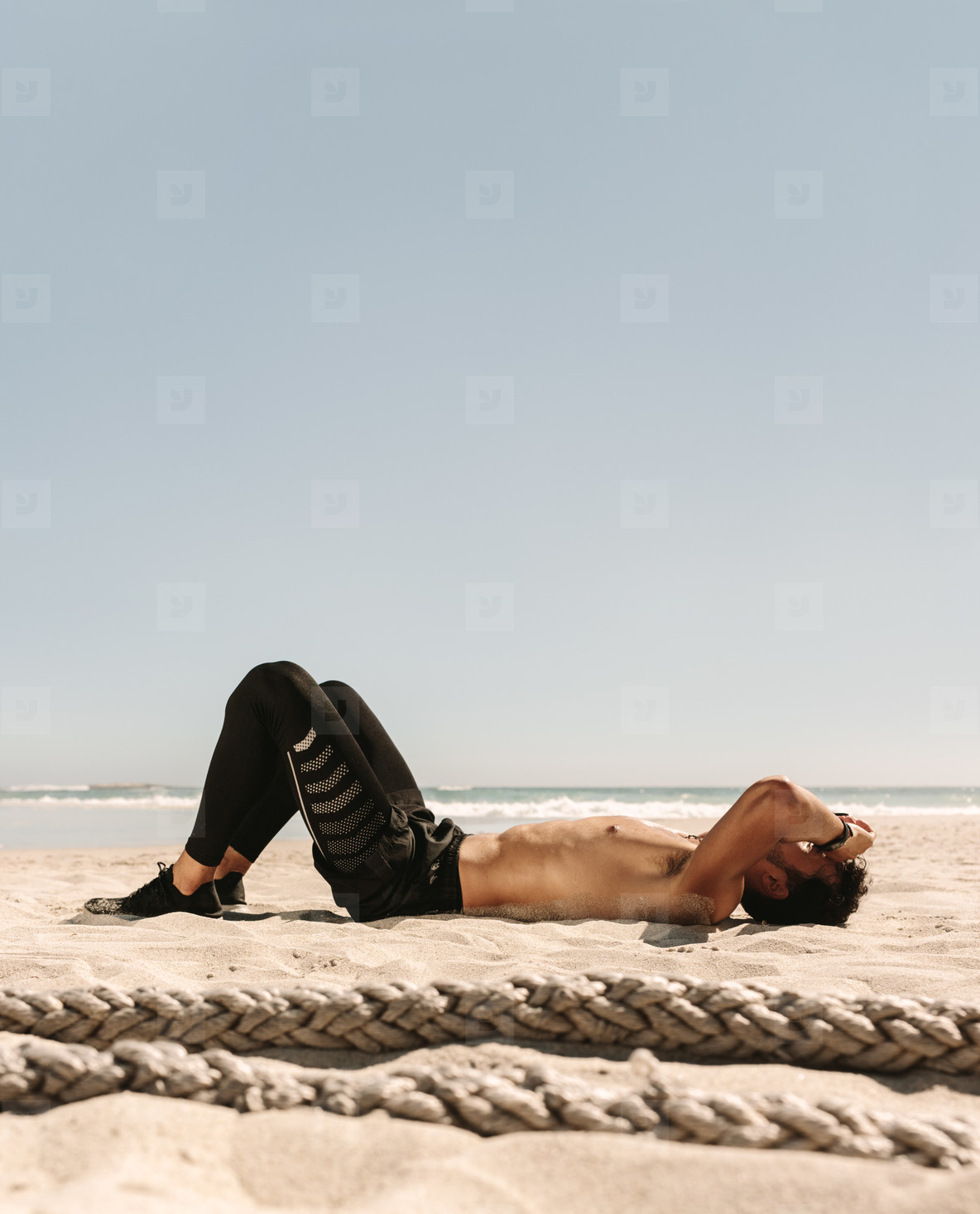 Man relaxing after workout on the beach