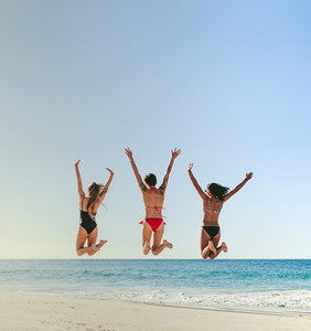Women jumping in air at the beach