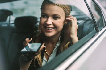Businesswoman making phone call in cab