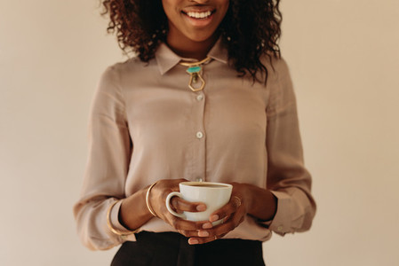 Woman in formal attire holding a coffee cup