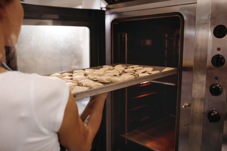 Female baker baking rolls