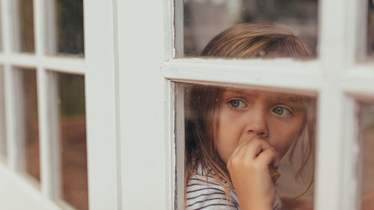 Little girl sitting by the window