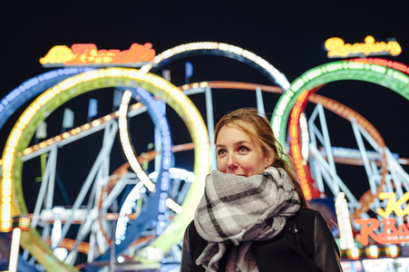 Portrait of a happy young woman on a funfair at night