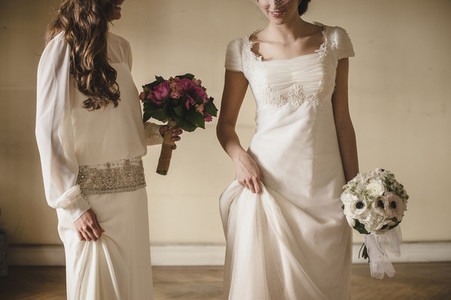 Two young brides holding her bridal bouquets