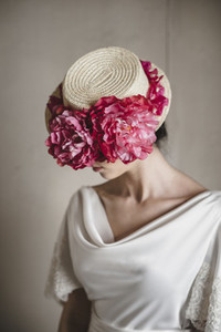 Close up of bride wearing a hat with floral arrangement