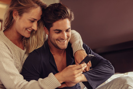 Couple looking at smart phone and smiling