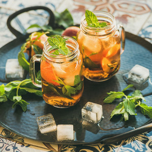 Summer refreshing cold peach ice tea with mint  square crop