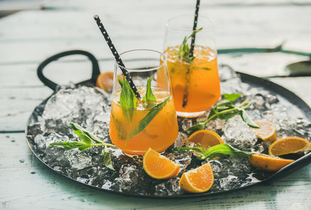Refreshing cold alcoholic summer cocktail with orange on tray