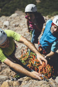 Young couple of climbers attending to rockclimbing guide instructions in a  route in Los Mallos de Riglos Spain