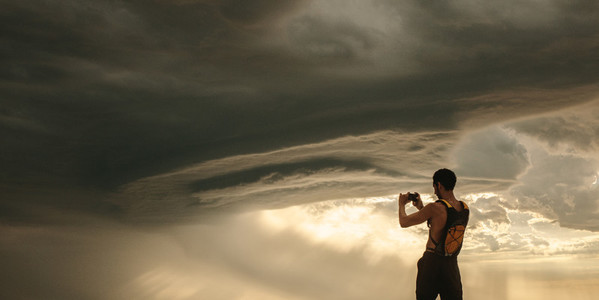Athlete taking pictures of dramatic sky