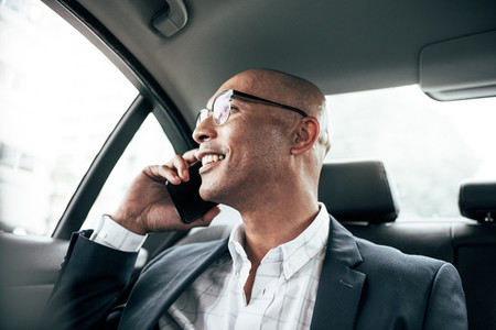 Businessman talking on mobile phone sitting in car