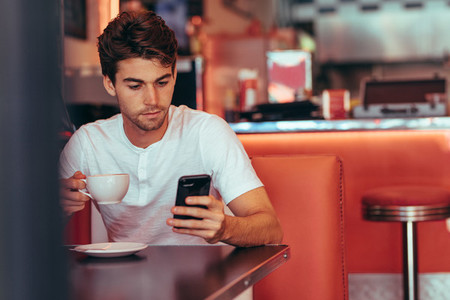 Man sitting at a restaurant looking at his mobile phone
