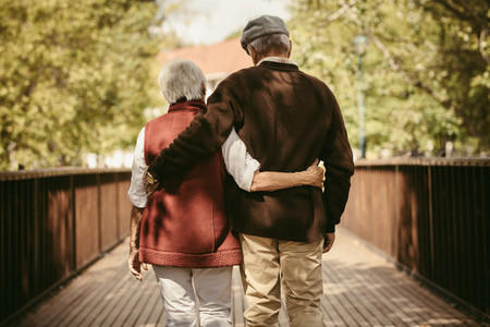 Senior couple walking through a park