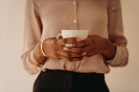 Woman in formal attire holding a coffee cup