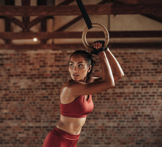 Female athlete exercising with gymnastic rings