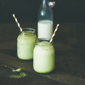 Refreshing iced coconut matcha latte drink in jars  square crop