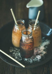 Cold Thai iced tea in bottles with milk  dark background
