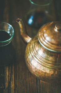 Oriental tea pot and black tea in tulip glasses