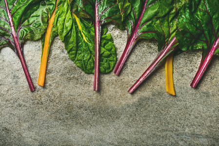 Flat lay of fresh leaves of swiss chard over concrete background
