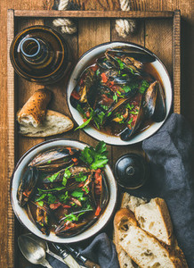 Flat lay of boiled mussels in tomato sauce and light beer
