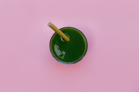 Green smoothie drink isolated on pink background