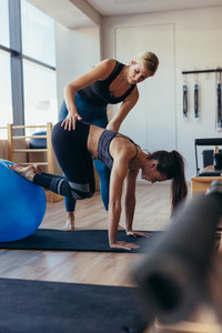 Pilates woman training with an exercise ball at gym