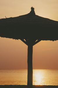 Tropical beach umbrella sunset