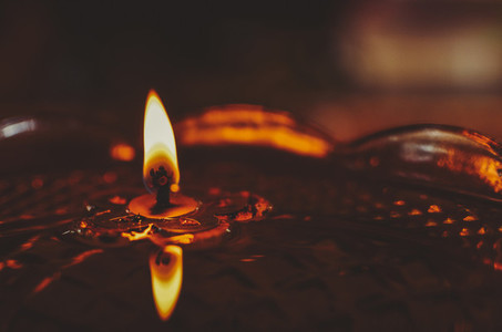 Burning Candle Floating In Oil