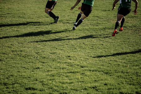 Rugby team playing match at grassy field