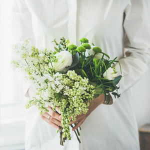 Young woman wearing white clothes holding flowers bouquet  square crop