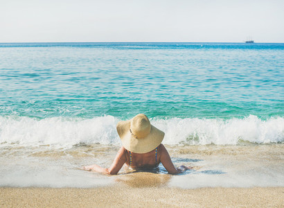 Senior woman tourist in bikini lying on sand enjoying sea
