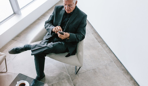 Senior businessman texting with mobile phone