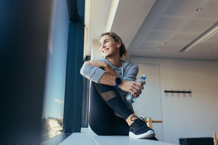 Woman relaxing after workout sitting in a pilates gym