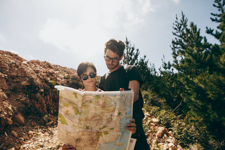 Explorer couple looking at a map for navigation
